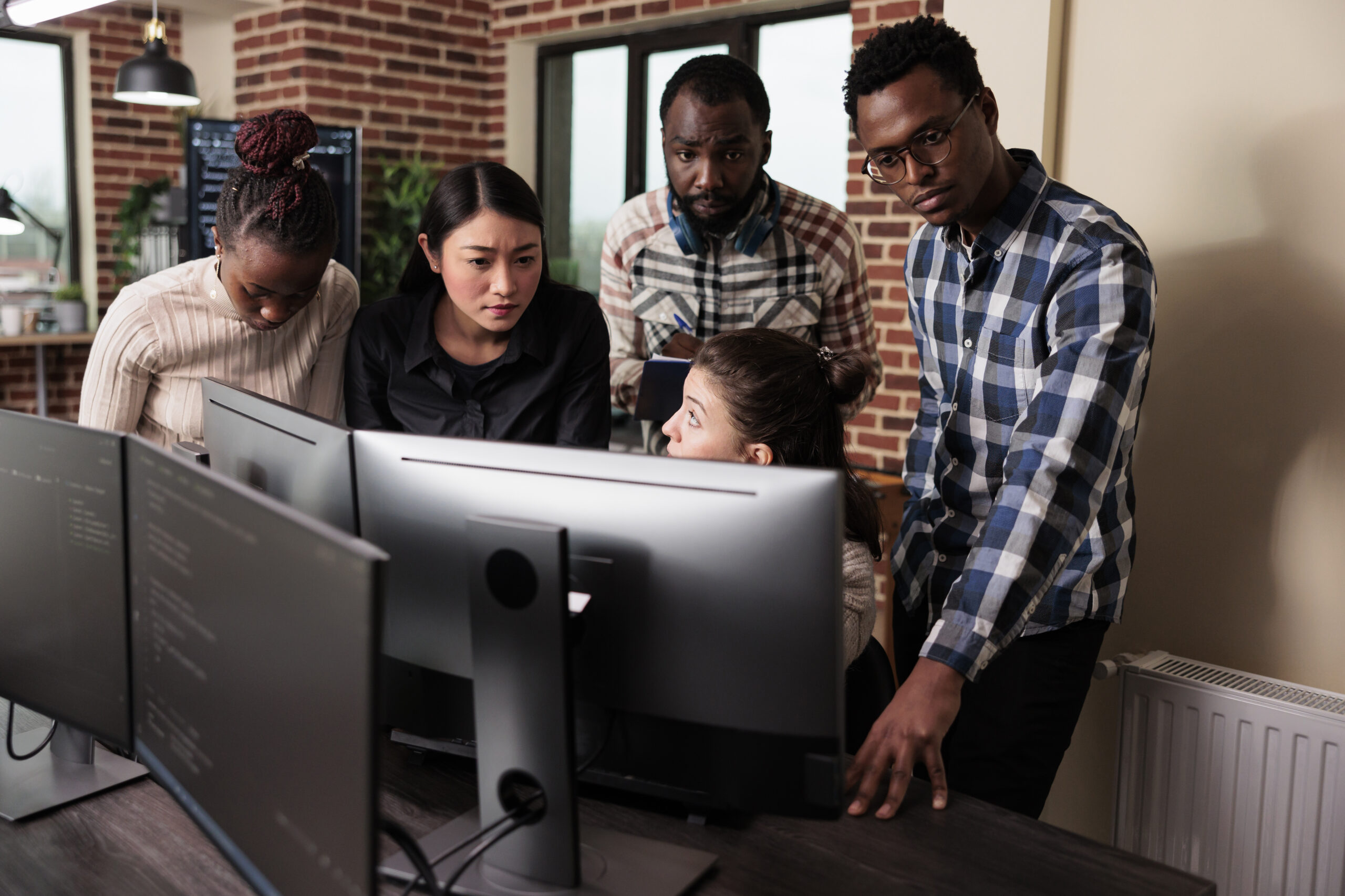 Multiethnic cyber security team developing software algorithm for information processing and network optimization. Informational agency multiracial tech engineers programming application while using computer.
