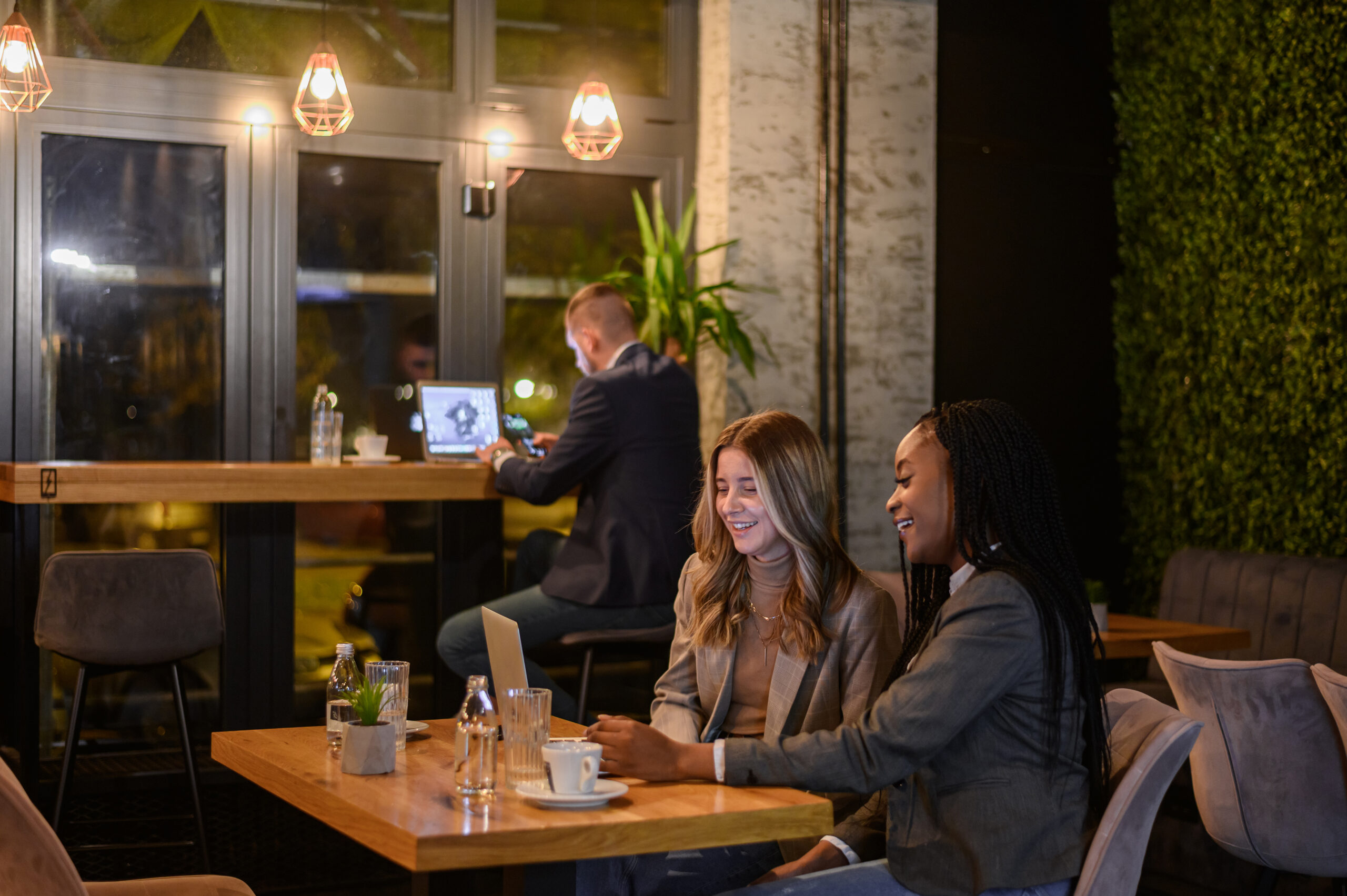 Two businesswoman having a meeting in a cafe while using a laptop